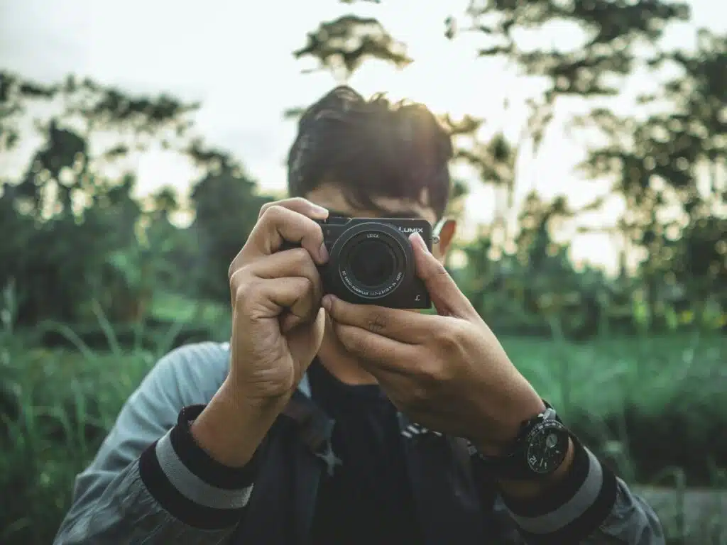 Digitale camera in actie buiten vastgehouden oor een man
